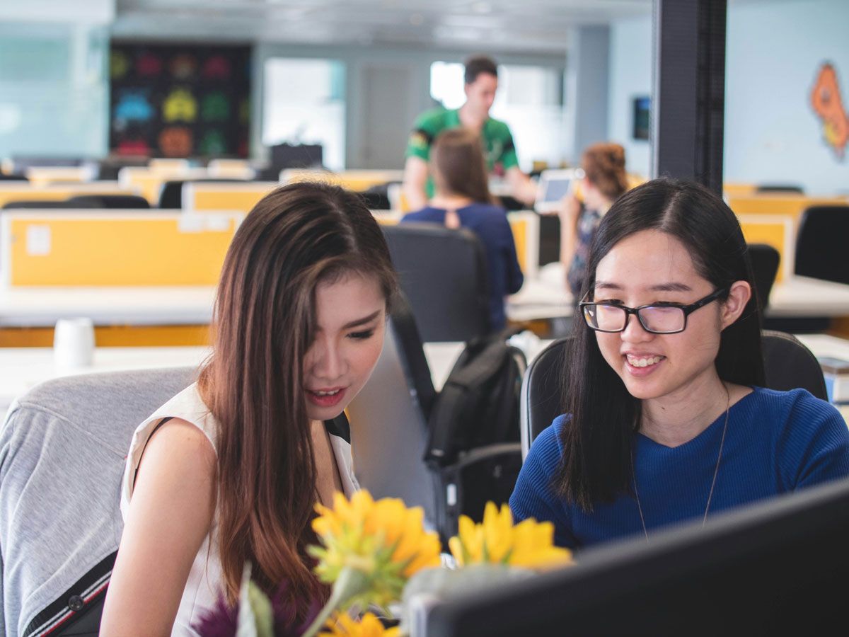 Two executive women in a casual discussion at their workplace