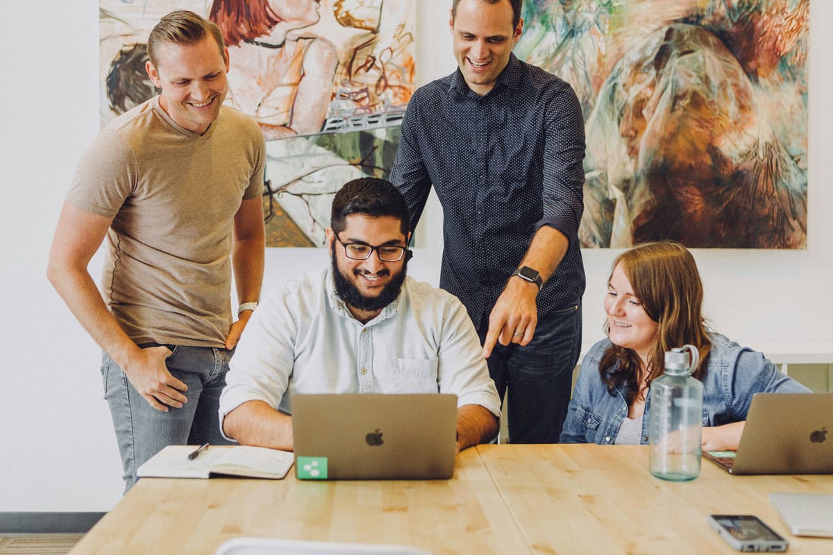 A group of executives sharing a screen and laughing