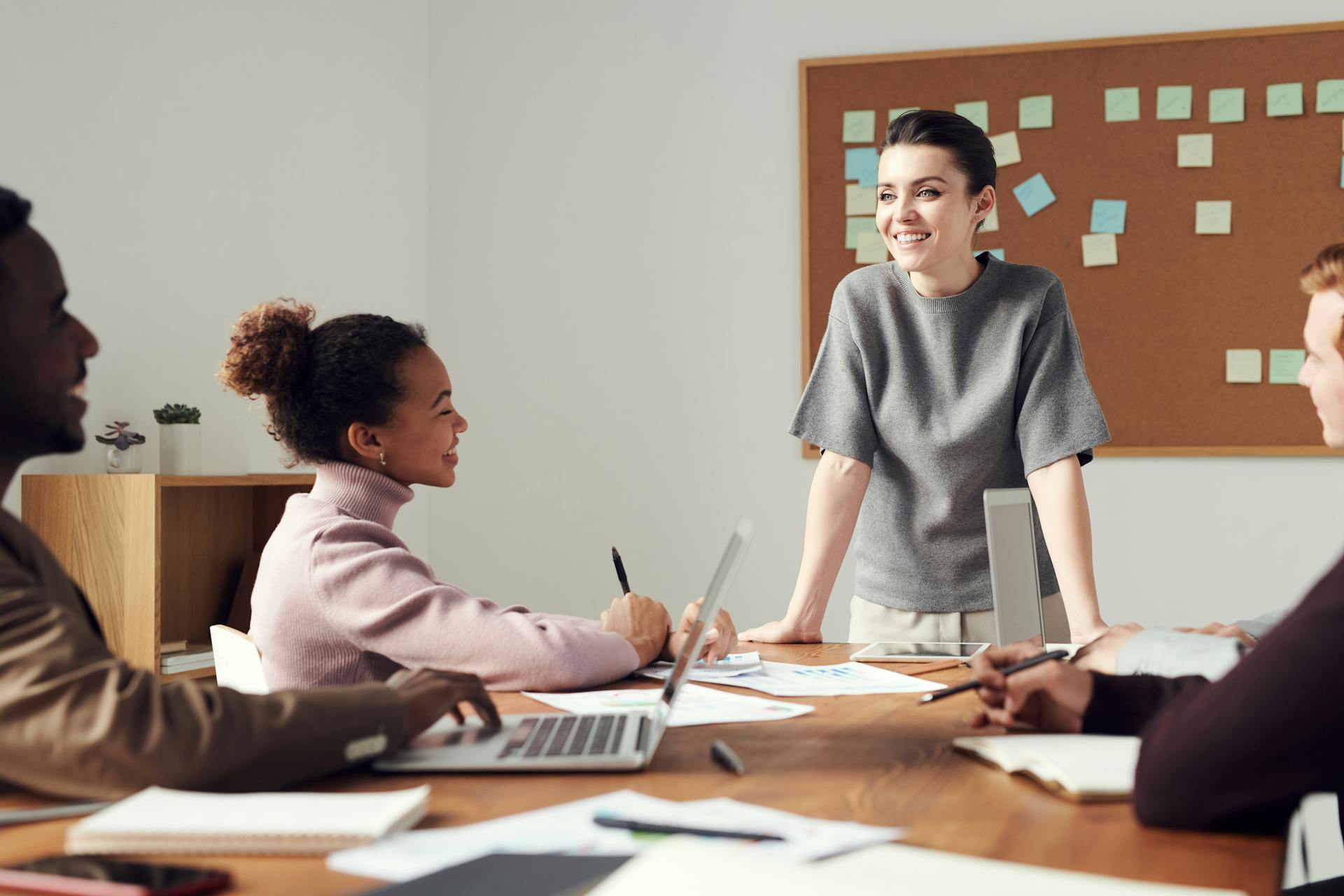 A young woman executive presenting to colleagues in a modern meeting room